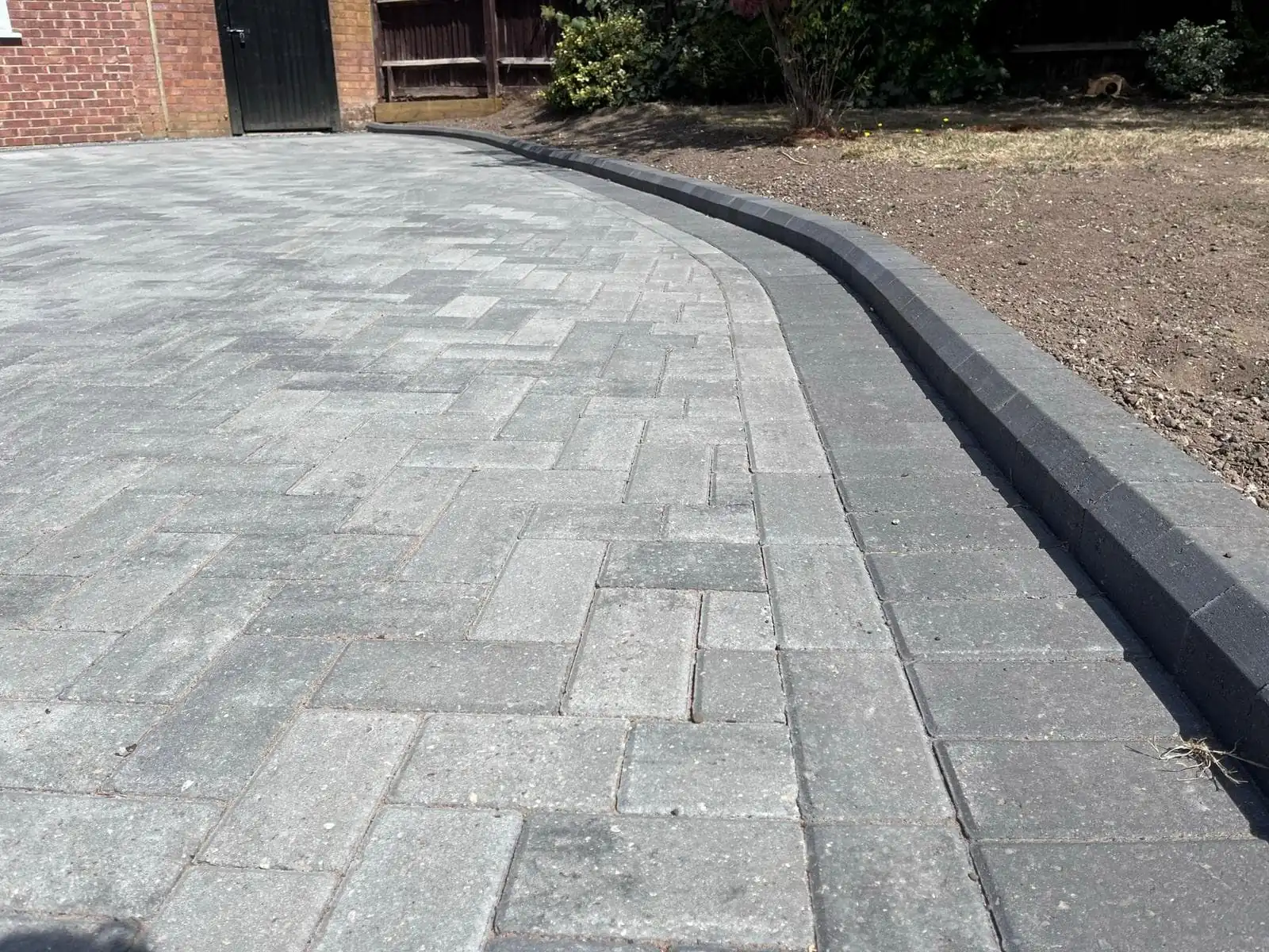 Grey block paved driveway with a dark kerb edging
